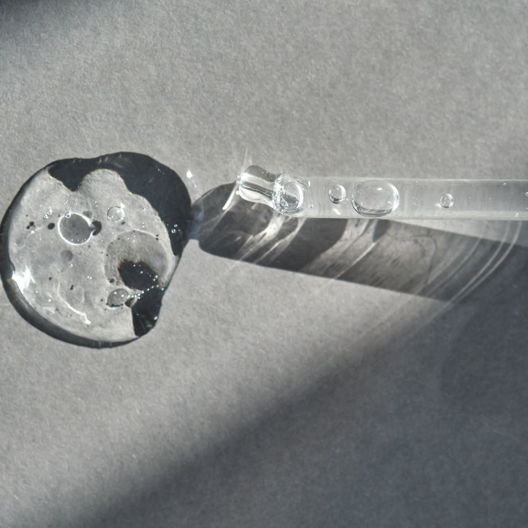 Goutte de sérum et pipette en verre, photographie en noir et blanc