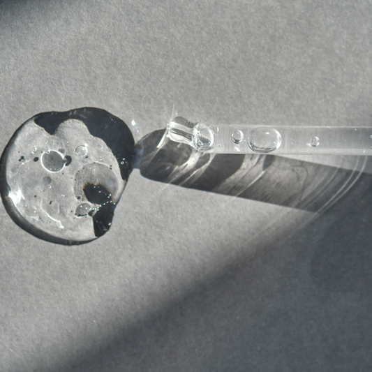 Goutte de sérum et pipette en verre, photographie en noir et blanc