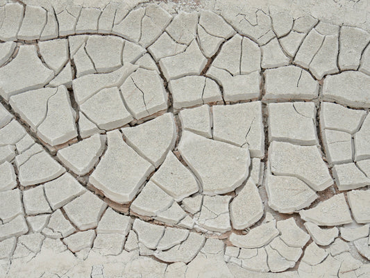 Terre craquelée par la sécheresse, image d'une peau qui manque d'hydratation